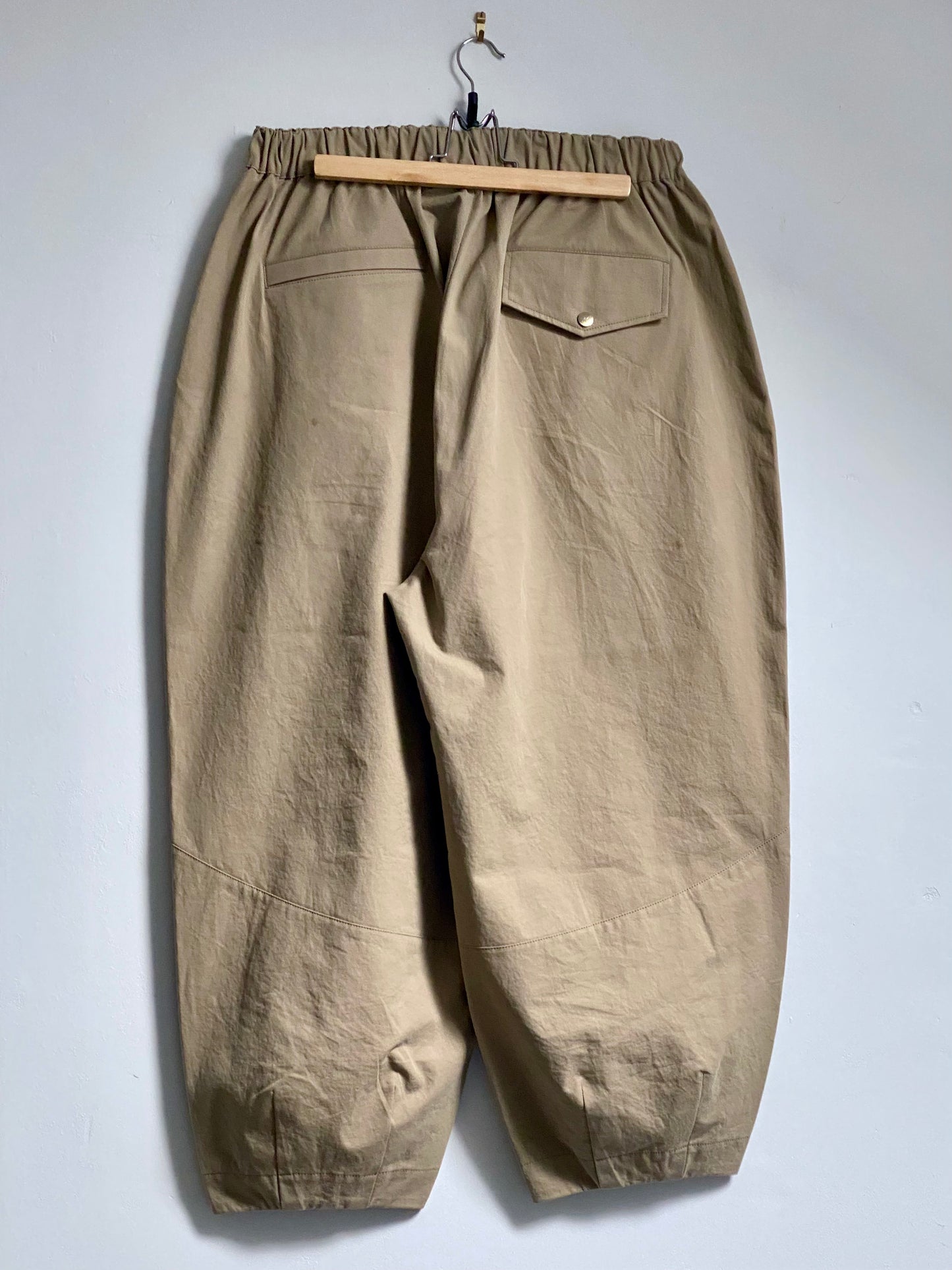 Beige trousers with 2 back pockets against a white background