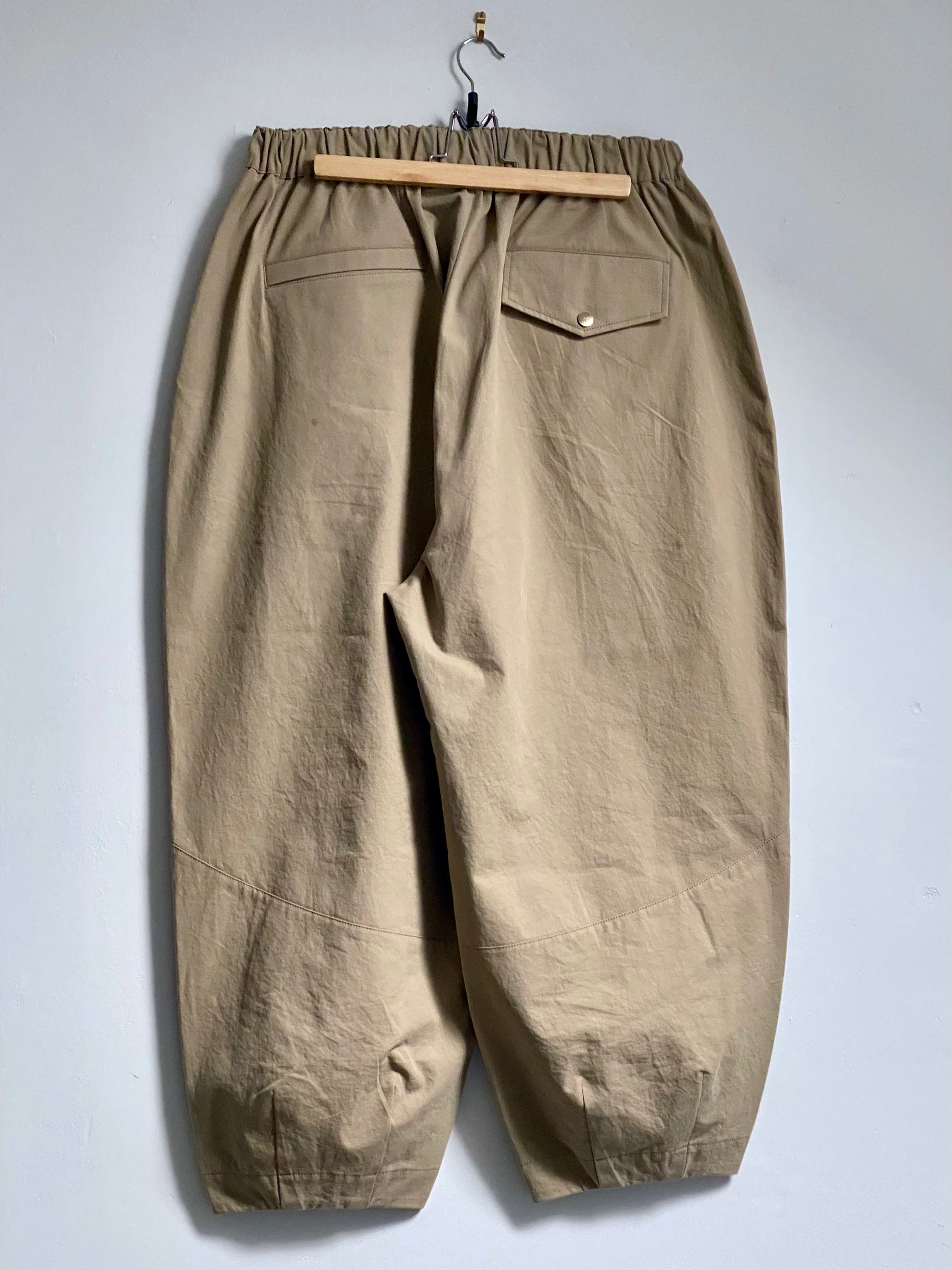 Beige trousers with 2 back pockets against a white background