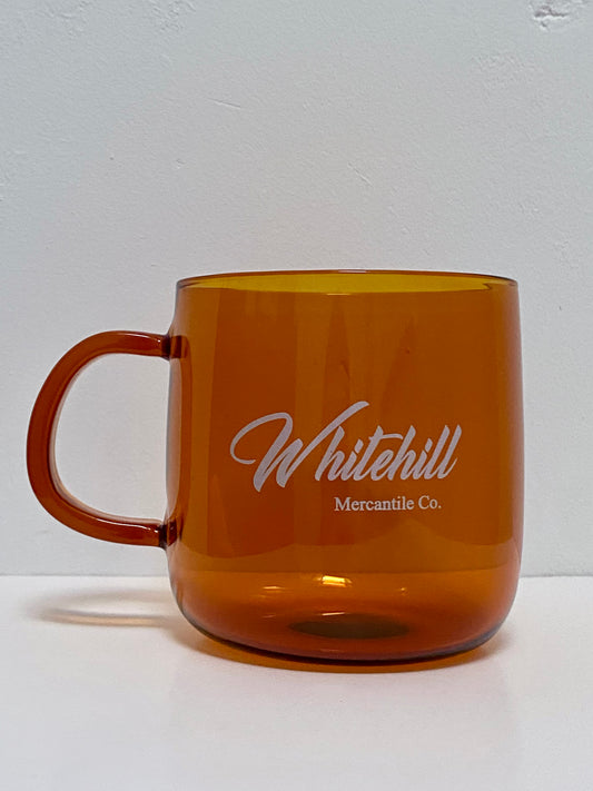 Amber glass cup with Whitehill branding in white